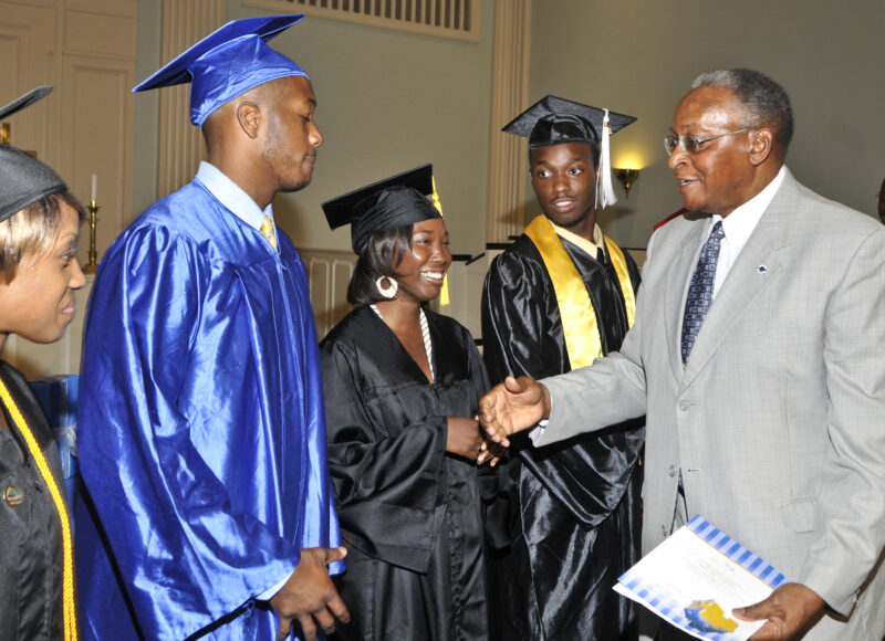 Dr. John T. Crawford, founder of Greater Steps Scholars, shakes the hands of recent graduates.